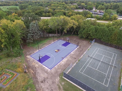 Outdoor residential sports area with a gray and purple basketball court and Minnesota Vikings central logo in Wasuau.