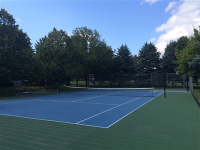  Outdoor residential sports court with a blue and green surface, featuring a tennis net in Middleton.