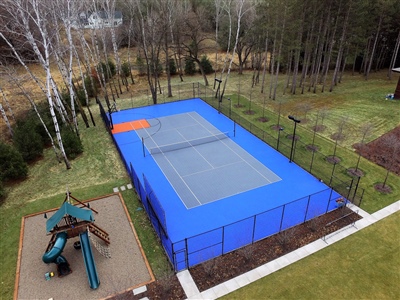  Outdoor residential sports court with a blue surface and orange accent, featuring a tennis net.