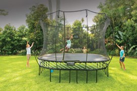 Black trampoline with a black safety net and yellow spring free layer and a child jumping on it.