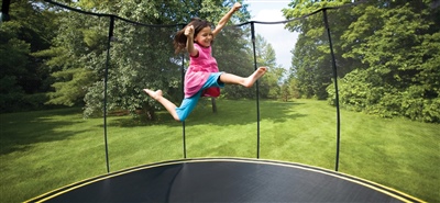 Black trampoline with a black safety net and a child jumping on it. 