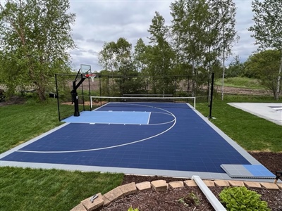  A basketball court with a navy and blue surface, grey border, and white lines.