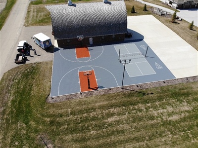 Outdoor residential sports area with a gray and orange basketball court and a tennis court in Bayside.