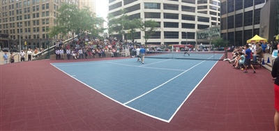 Outdoor sports court with a blue and red surface, featuring a tennis net in Peuwakee.