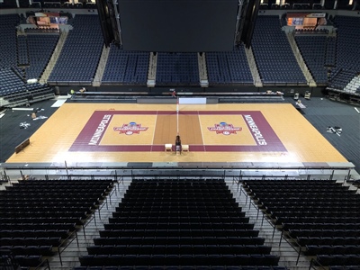 Indoor volleyball court with wooden floors and maroon borders. 